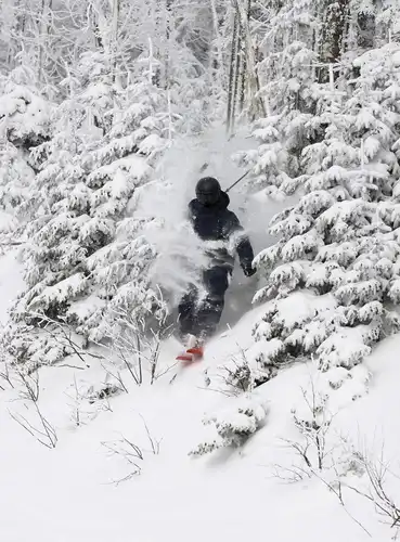 A skier hurtling down the snowy slopes near real estate project in Mont Tremblant